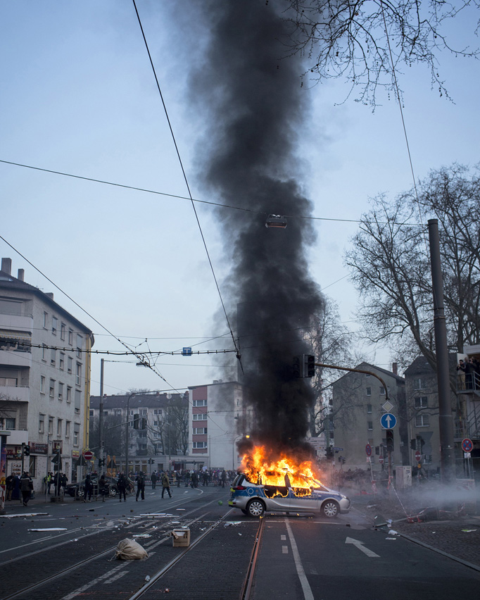 A police car burns down after it was attacked by violent protesters.