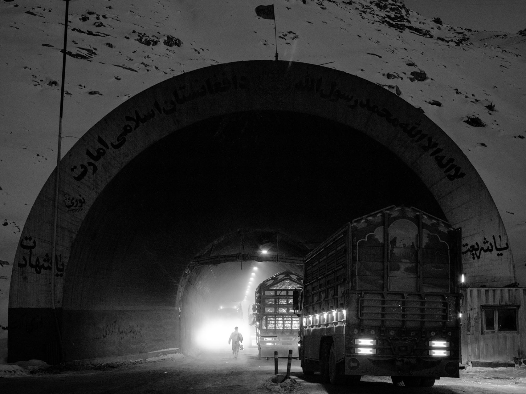 A co-driver runs to reach his truck that has just entered the Northern side of the Salang tunnel which has been painted with Taliban's slogan "Either Sharia or Martyrdom".